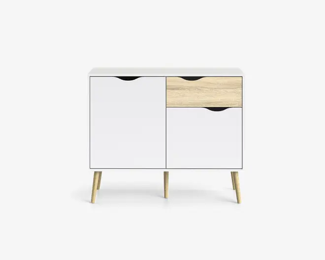 Moderne skab med hvid finish, der har to låger og én skuffe. Skuffen har en lys træstruktur på fronten, mens lågerne er helt hvide. Alle greb er udskårne for et stilrent udtryk. Skabet står på fire skråtstillede ben i lyst træ, hvilket giver et minimalistisk og skandinavisk inspireret design.