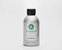 En sølvfarvet flaske med sort skruelåg, der har et grønt 'G'-logo og mærket 'Guardian Furniture Care' på forsiden. Etiketten viser også produktnavnet 'G-Polish' med fed skrift samt yderligere tekst i mindre skrift med 'G-Polering' og 'G-Politur.' Flasken har et slankt, moderne design og ser ud til at være lavet af metal eller metallisk plast.