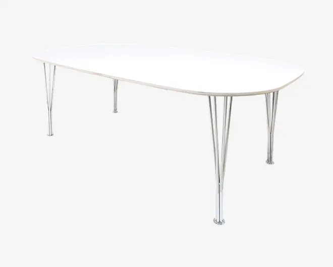 Et moderne bord med en glat, hvid, oval bordplade og seks slanke ben i kromfinish, arrangeret i par for ekstra stabilitet. Bordet har rene linjer og et minimalistisk design, der passer til moderne indretning.