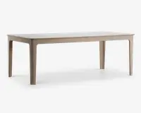 Rektangulært bord med lys træramme og ben, samt en glat, hvid bordplade. Designet er minimalistisk med blødt afrundede hjørner og kanter, og benene er let tilspidsede for et moderne udtryk.