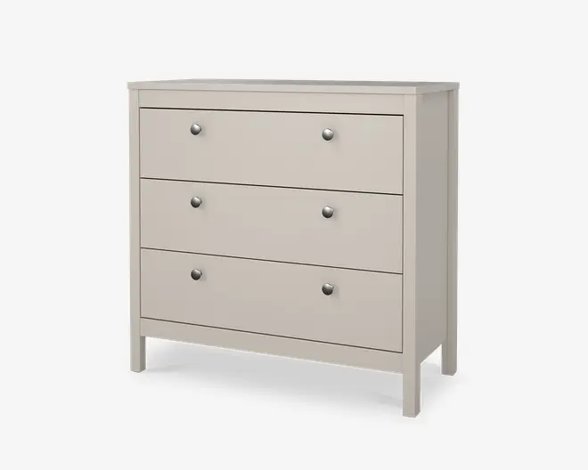 En lys beige kommode med tre rummelige skuffer, hver udstyret med to runde metalgreb for nem åbning. Kommoden har et enkelt, moderne design med rene linjer og en flad top, understøttet af fire solide ben. Overfladen er glat og mat, hvilket giver et moderne udtryk, der passer til forskellige rumtyper.