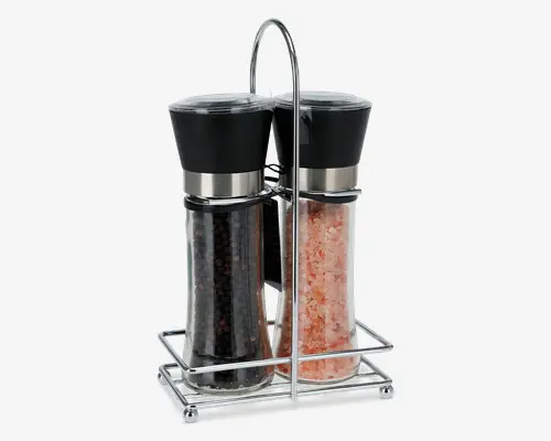 Sæt med to gennemsigtige kværne med sorte låg og detaljer i rustfrit stål, den ene fyldt med sorte peberkorn og den anden med lyserøde Himalayasaltkrystaller. Begge kværne står i en elegant holder af sølvfarvet metal med hank, så de er nemme at bære. De klare beholdere gør det let at se indholdet og holde øje med, hvor meget der er tilbage.