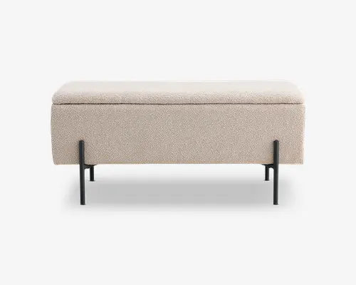 Rektangulær bænk med en blød, lysebeige polstret pude og et minimalistisk design. Bænken har en solid sort metalramme med fire lige ben og en vandret støttebjælke tæt på bunden, hvilket giver et moderne og stilrent udtryk. Betrækket har et diskret tekstureret stof, og det samlede udseende er enkelt og nutidigt.