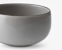 En rund skål med glat overflade og blank, lysegrå yderside og inderside. Skålen har et enkelt, minimalistisk design uden synlige mønstre, hanke eller dekorationer. Kanten er let afrundet, og formen er blødt buet, hvilket giver et moderne og elegant udtryk.