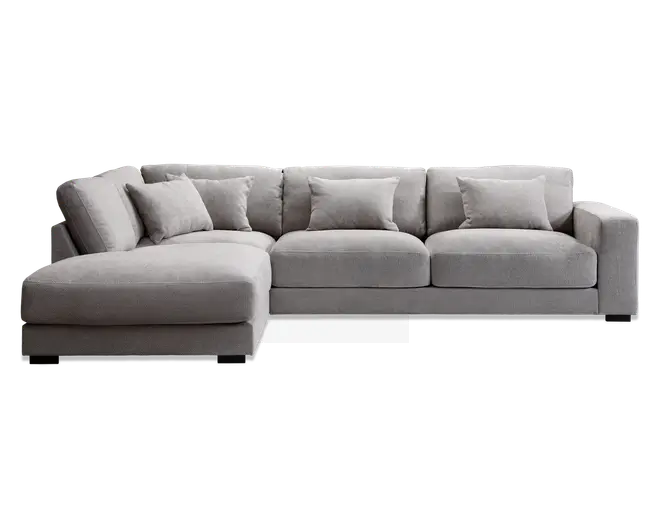 Moderne hjørnesofa i lysegråt stof med venstrevendt chaiselong. Sofaen har brede, dybe sæder og bløde ryghynder for ekstra komfort. Inkluderer fem matchende pyntepuder. Designet er enkelt og minimalistisk med lige linjer og lavprofilerede armlæn.
