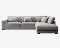 Moderne hjørnesofa i lysegråt stof med højrevendt chaiselong. Sofaen har brede, lavprofilerede armlæn og dybe sæder for ekstra komfort. Den leveres med fem matchende ryghynder, som giver ekstra støtte og et blødt, indbydende udtryk. Betrækket har en diskret tekstur, og det samlede design er enkelt og moderne, velegnet til rummelige stuer.
