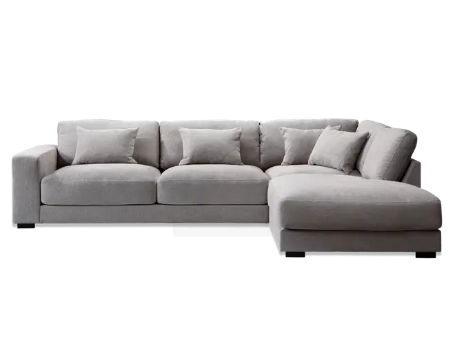 Moderne hjørnesofa i lysegråt stof med højrevendt chaiselong. Sofaen har brede, lavprofilerede armlæn og dybe sæder for ekstra komfort. Den leveres med fem matchende ryghynder, som giver ekstra støtte og et blødt, indbydende udtryk. Betrækket har en diskret tekstur, og det samlede design er enkelt og moderne, velegnet til rummelige stuer.