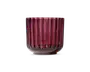 En dyb rød glasbeholder med cylindrisk form og lodret rillet tekstur. Glasset er tykt og har en blank finish, hvilket giver det et moderne og elegant udseende. Bunden er let afrundet, og kanten er glat, hvilket gør den egnet til at opbevare små genstande eller fungere som et dekorativt element.