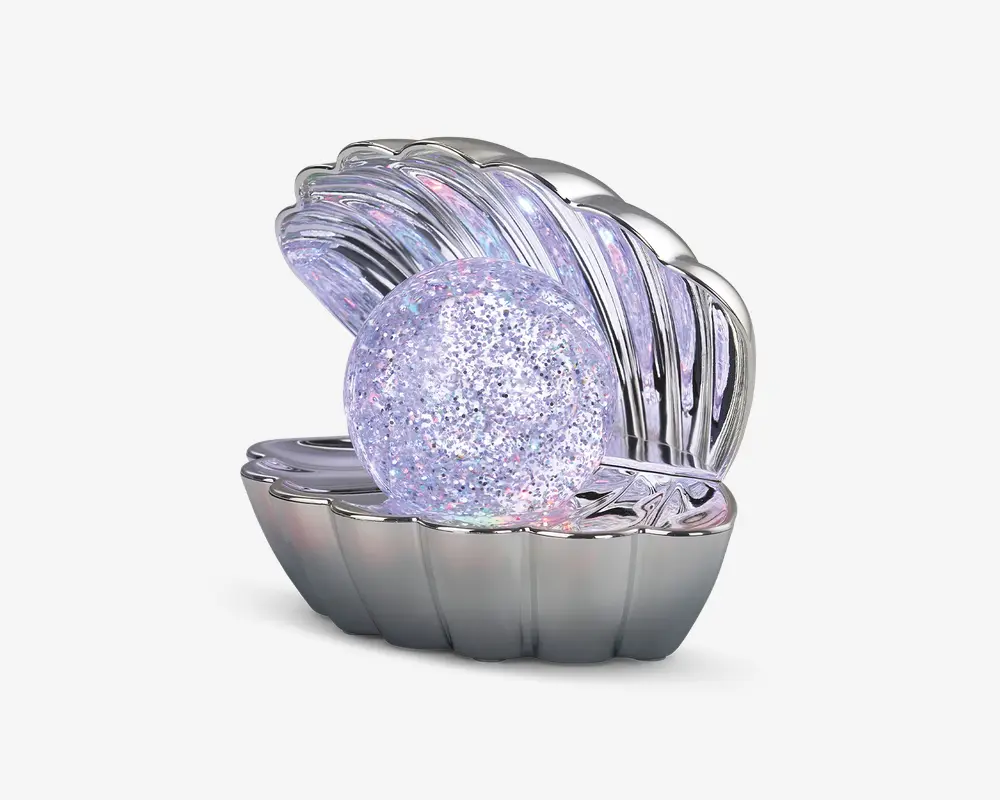 En dekorativ genstand formet som en åben muslingeskal med en blank, sølvfarvet overflade. Inde i skallen ligger en stor, rund kugle dækket af glitrende, iriserende farver, der ligner en perle. Designet er elegant og iøjnefaldende, velegnet til udstilling eller som en unik gave.