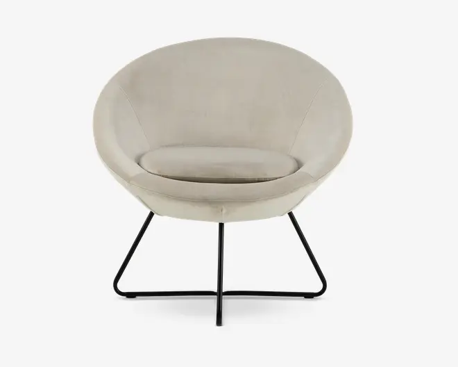 En moderne lænestol med rund, skålformet ryg og sæde betrukket med lysebeige stof. Stolen har en blød, aftagelig siddepude for ekstra komfort. Den står på en slank, sort metalramme med fire ben, der buer udad for stabilitet og et moderne udtryk.