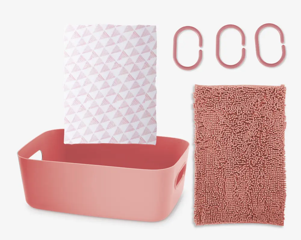 Sættet indeholder en rektangulær lyserød opbevaringskasse med håndtag på siderne, en blød lyserød chenille-måtte med tekstur, et hvidt håndklæde med lyserødt geometrisk trekantmønster samt tre lyserøde ovale plastikkroge. Alle dele er farvekoordinerede i lyserøde nuancer og designet til organisering og praktisk brug.