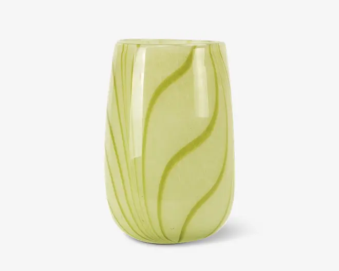 Et transparent, lysegrønt glas med en glat, afrundet form og let indsnævret kant. Overfladen har diskrete, bølgede linjer i en mørkere grøn farve, som skaber et elegant, organisk mønster. Glasset har en blank finish, hvilket giver det et moderne og stilfuldt udtryk.