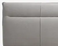 Lys grå polstret overflade med blødt, tekstureret stof. Designet har rene, lige syninger, der deler overfladen op i rektangulære sektioner og giver et moderne og minimalistisk udtryk. Polstringen ser tyk og komfortabel ud med diskrete syningsdetaljer for ekstra stil.