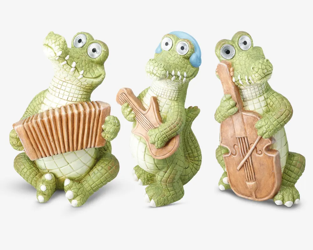 Tre finurlige krokodillefigurer med overdrevne, tegneserieagtige træk og store, runde øjne. Den ene krokodille holder et harmonika, den anden spiller guitar og har blå hovedtelefoner på, og den tredje holder en cello. Alle figurerne har en grøn, tekstureret krop med hvid bug og er placeret, som om de optræder med musik sammen.