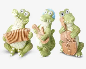 Tre finurlige krokodillefigurer med overdrevne, tegneserieagtige træk og store, runde øjne. Den ene krokodille holder et harmonika, den anden spiller guitar og har blå hovedtelefoner på, og den tredje holder en cello. Alle figurerne har en grøn, tekstureret krop med hvid bug og er placeret, som om de optræder med musik sammen.
