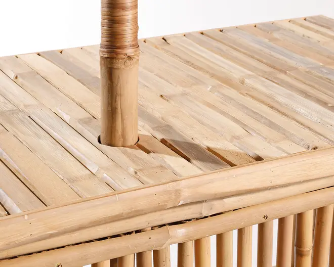 Nærbillede af et møbel lavet af naturlig bambus. Billedet fremhæver de glatte, lyse bambuslameller, der danner en flad overflade, med en lodret bambusstang, der er sat gennem en rund åbning. Håndværket viser tæt omviklet rattan eller bast omkring toppen af stangen for ekstra stabilitet. Overfladen er naturlig og fremhæver bambussens unikke struktur og åretegning.