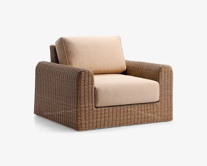 Lænestol med en ramme i fletlook i naturlig brun farve. Har tykke, beige sæde- og ryghynder for ekstra komfort. Stolen har brede armlæn og en firkantet, moderne form, velegnet til både indendørs sopm udendørs brug.