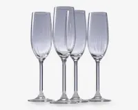 Sæt med fire klare glasfløjter med høje, slanke skåle og lange stilke. Hver glas har diskrete lodrette riller langs skålen, hvilket giver et elegant og tekstureret udtryk. Fodene er brede og flade for stabilitet.