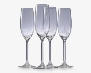 Sæt med fire klare glasfløjter med høje, slanke skåle og lange stilke. Hver glas har diskrete lodrette riller langs skålen, hvilket giver et elegant og tekstureret udtryk. Fodene er brede og flade for stabilitet.