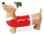 En festlig keramisk figur formet som en gravhund med blank overflade. Hunden har en rød sweater med små grønne prikker og hvid kant samt en grøn nissehue med hvid kant. Figuren har et glad udtryk med lukkede øjne og næsen løftet, hvilket giver den et muntert og finurligt udseende.