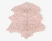 Blødt, fluffy tæppe med en naturlig, ujævn form og en lys pastelrosa farve. Overfladen har lange, pjuskede fibre, der giver en luksuriøs og behagelig tekstur, perfekt til at tilføje varme og komfort til et rum. Kanterne er uregelmæssige og ligner et naturligt skind.