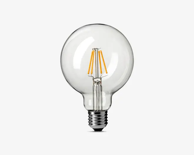 Klar glaspære med rund, globusformet design. Indeni ses fire lodrette LED-filamenter, der er symmetrisk placeret omkring den centrale akse. Soklen er en standard skruefatning, metallisk og reflekterende. Pæren har et moderne, minimalistisk udseende, velegnet til dekorativ belysning.