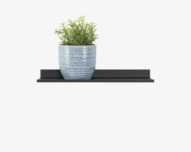 En dekorativ plante med grønne blade i en tekstureret, lyseblå keramikkrukke. Krukken har en rund form og står på en slank, sort metalhylde med et minimalistisk design. Hylden har en flad overflade og en lille kant bagtil for støtte.