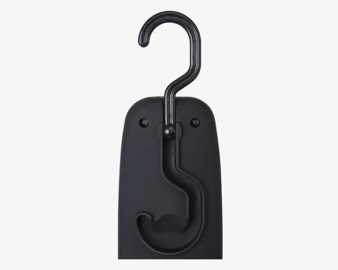 Et nærbillede af en sort plastikgenstand med en solid metalkrog øverst. Krogen kan drejes og foldes ned i en formstøbt rille på forsiden af enheden for kompakt opbevaring. Overfladen er mat og glat, og der er to synlige skruer, som fastgør krogmekanismen. Designet er minimalistisk og funktionelt, velegnet til ophængning eller transport af genstande.