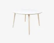 Et rundt bord med en glat, hvid bordplade og fire lyse træben, der er let skråtstillede udad. Designet er minimalistisk og moderne med rene linjer og en slank profil. Bordet virker solidt og egner sig til små spiseområder eller som et alsidigt møbel.