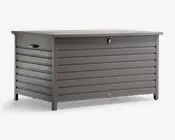 Rektangulær opbevaringsboks med moderne, horisontale lameller i mat grå finish. Boksen har et fladt låg med lås for sikkerhed samt solide sidehåndtag for nem løftning. Hævede ben giver stabilitet og holder boksen over jorden. Velegnet til både udendørs og indendørs brug med vejrbestandigt og holdbart design.