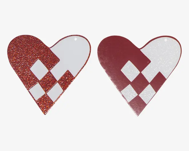 To hjerteformede dekorationsstykker, det ene i rød glitter med hvide geometriske detaljer og det andet i blank bordeaux med hvide glimmerdetaljer, begge med et lille ophængshul øverst.
