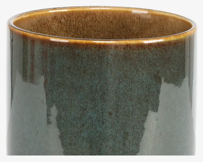 Et cylindrisk keramikkar med en blank, plettet glasur. Ydersiden har en blanding af jordnære grønne og blå nuancer med en diskret farveovergang, mens kanten og indersiden er i en varm, gyldenbrun farve. Overfladen er glat og reflekterende, og designet er enkelt og moderne.