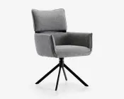 En moderne stol med gråt polstret sæde, ryglæn og armlæn. Stolen har en blød, polstret ryg for ekstra komfort og et kantet, firkantet design. Den står på en sort metalfod med fire skråtstillede ben og kan dreje, hvilket giver et moderne udtryk, der passer til både kontor og hjem.