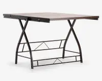 Rektangulært bord med en bordplade i lyst trælook og et robust sort metalstel. Stellet har X-formede sidestøtter og geometriske tværstænger for ekstra stabilitet. Bordpladen har en glat overflade med synlig træstruktur, og designet er moderne og industrielt.