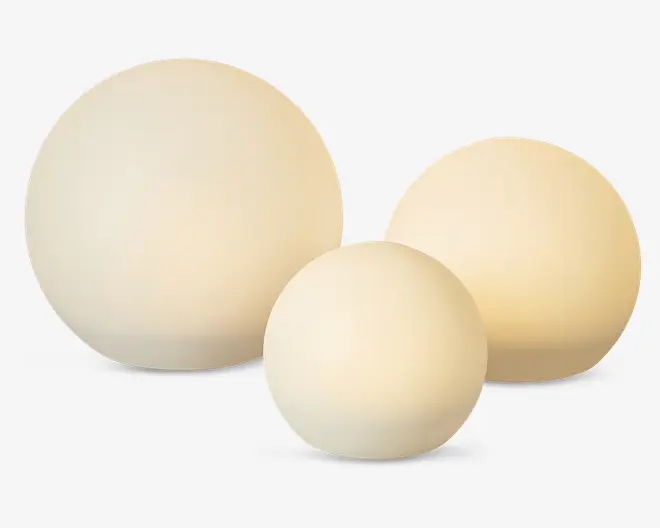 Sæt med tre kugleformede lamper i forskellige størrelser, hver med en glat, mat overflade og et varmt hvidt skær. Lamperne har et minimalistisk, moderne design og udsender et blødt, diffust lys, hvilket gør dem velegnede til stemningsbelysning i forskellige rum.