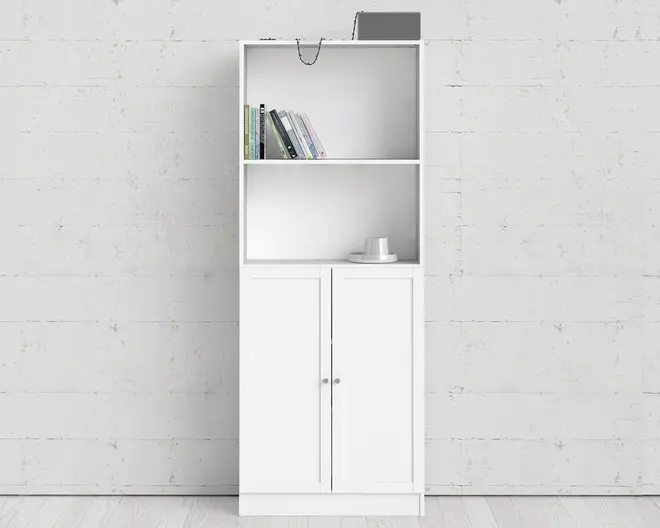 Høj, hvid reolenhed med to åbne hylder øverst og et skab med to låger nederst. De åbne hylder viser nogle bøger, en bærbar computer og en kop med underkop. Skabslågerne har enkle, runde greb. Designet er minimalistisk og moderne med rene linjer og en glat overflade.