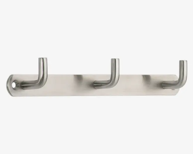Vægmonteret holder i børstet rustfrit stål med tre jævnt fordelte cylindriske kroge. Hver krog er afrundet for enden for sikker ophængning, og holderen har en glat, moderne overflade. Monteringshullerne er synlige i hver ende for nem installation.