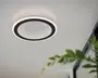 Moderne loftlampe med et cirkulært design, der har en sort inderring og en hvid yderring. Midten har et tekstureret, prikket mønster, som skaber en subtil optisk illusion og giver dybde og visuel interesse. Lampen udsender et blødt, diffust lys, der passer godt til moderne indretning.