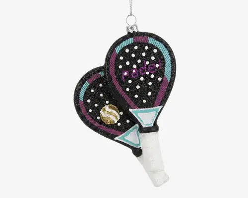 Denne pynt forestiller to overlappende padelbat med sorte flader dekoreret med hvide prikker og farverige detaljer i turkis, lilla og guld. På det ene bat står der 'padel' med lilla glimmer, og mellem battene er der placeret en lille gul og hvid bold. Håndtagene er omviklet med hvidt og har turkise trekantede mønstre nær bunden. Øverst er der en sølvfarvet ophængssnor.