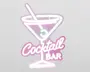 Neonskilt med et martiniglas, en rørepind og en oliven, omkranset af lyserøde og hvide lys. Teksten 'Cocktail Bar' står under glasset, hvor 'Cocktail' er skrevet med stor, kursiv skrift, og 'BAR' står med blokbogstaver. Designet har et retro og legende udtryk med en blød glød.