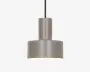 Et moderne pendellampe med en mat grå cylindrisk skærm. Designet har en høj, smal cylinder øverst, som går over i en bredere og kortere cylinder nederst, hvilket giver et geometrisk og minimalistisk udtryk. Lampen hænger i en sort ledning, og indersiden af skærmen er hvid for at forbedre lysrefleksionen.