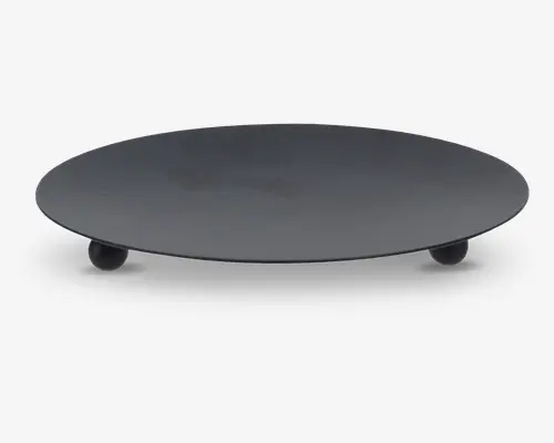 Rund, flad bakke i mat sort metal med glat overflade og tre små kugleformede fødder, der giver den et let hævet udtryk. Minimalistisk og moderne design, velegnet til servering eller dekoration.