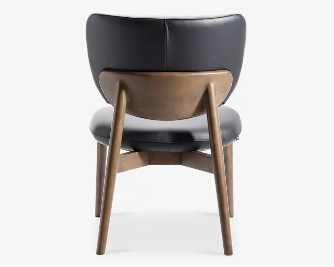 Stol med buet ryglæn i træ med en glat finish, kombineret med en polstret sæde og ryg betrukket med mørkegråt læder. Benene er lavet af massivt træ og vinklet udad for stabilitet. Designet har et moderne, retro-inspireret udtryk.