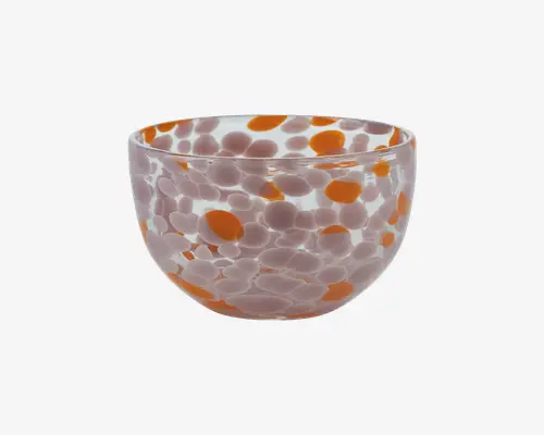 Rund glasskål med et mønster af store orange og mindre hvide pletter fordelt over hele overfladen. Skålen har en glat, blank finish og en let udadbuet kant. Det gennemsigtige glas gør, at de farvede pletter kan ses både indefra og udefra, hvilket giver et legende og moderne udtryk.