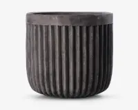 En rund, mørkegrå potte med mat finish og lodrette riller, der løber fra bunden op til lige under kanten. Kanten er glat og en smule tykkere end resten af potten, hvilket giver et moderne og industrielt udtryk.