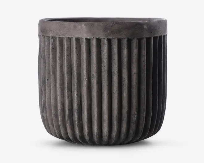 En rund, mørkegrå potte med mat finish og lodrette riller, der løber fra bunden op til lige under kanten. Kanten er glat og en smule tykkere end resten af potten, hvilket giver et moderne og industrielt udtryk.