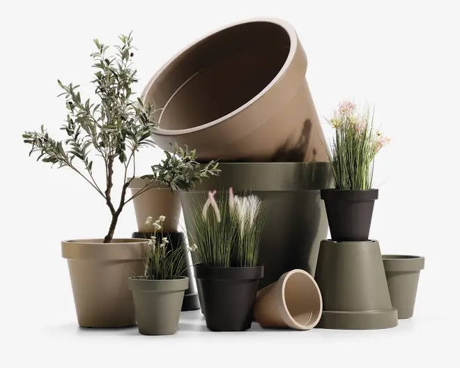En samling plantepotter i forskellige størrelser og farver, herunder beige, olivengrøn og sort. Nogle potter indeholder kunstige planter som græs, blomster og små træer, mens andre er tomme. Potterne har et enkelt, glat design med brede kanter og tilspidsede sider, velegnet til både indendørs og udendørs brug. Arrangementet viser potterne stablet og samlet, hvilket fremhæver deres alsidighed og størrelsesudvalg.