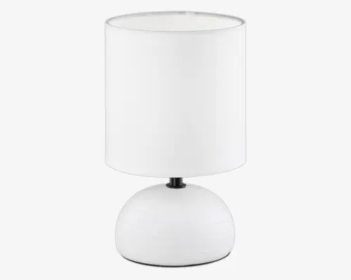 Bordlampe med en glat, rund keramisk fod og en cylindrisk lampeskærm i stof, begge i ren hvid farve. Foden har en mat overflade med diskrete vandrette teksturlinjer, og skærmen er en smule bredere end foden, hvilket giver lampen et moderne og minimalistisk udtryk.