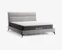 Moderne seng med et lysegråt polstret hovedgærde med rektangulære paneldetaljer, matchende polstret ramme og slanke sorte ben. Madrassen er middeltyk med hvid quiltet top og mørkegrå sider, hvor mærket 'SWEETNIGHT' er vist på siden.