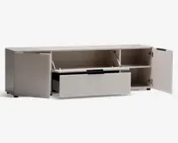 Rektangulær opbevaringsenhed i lys beige farve med et moderne, minimalistisk design. Har to sidekabinetter med hængslede låger, hver med en hylde til organisering. Midtersektionen har et vandret rum med en opadgående låge, der understøttes af metalarme, og nedenunder er der en bred udtræksskuffe med sort greb. Enheden står på korte, skjulte ben, hvilket giver et stilrent, svævende udtryk.